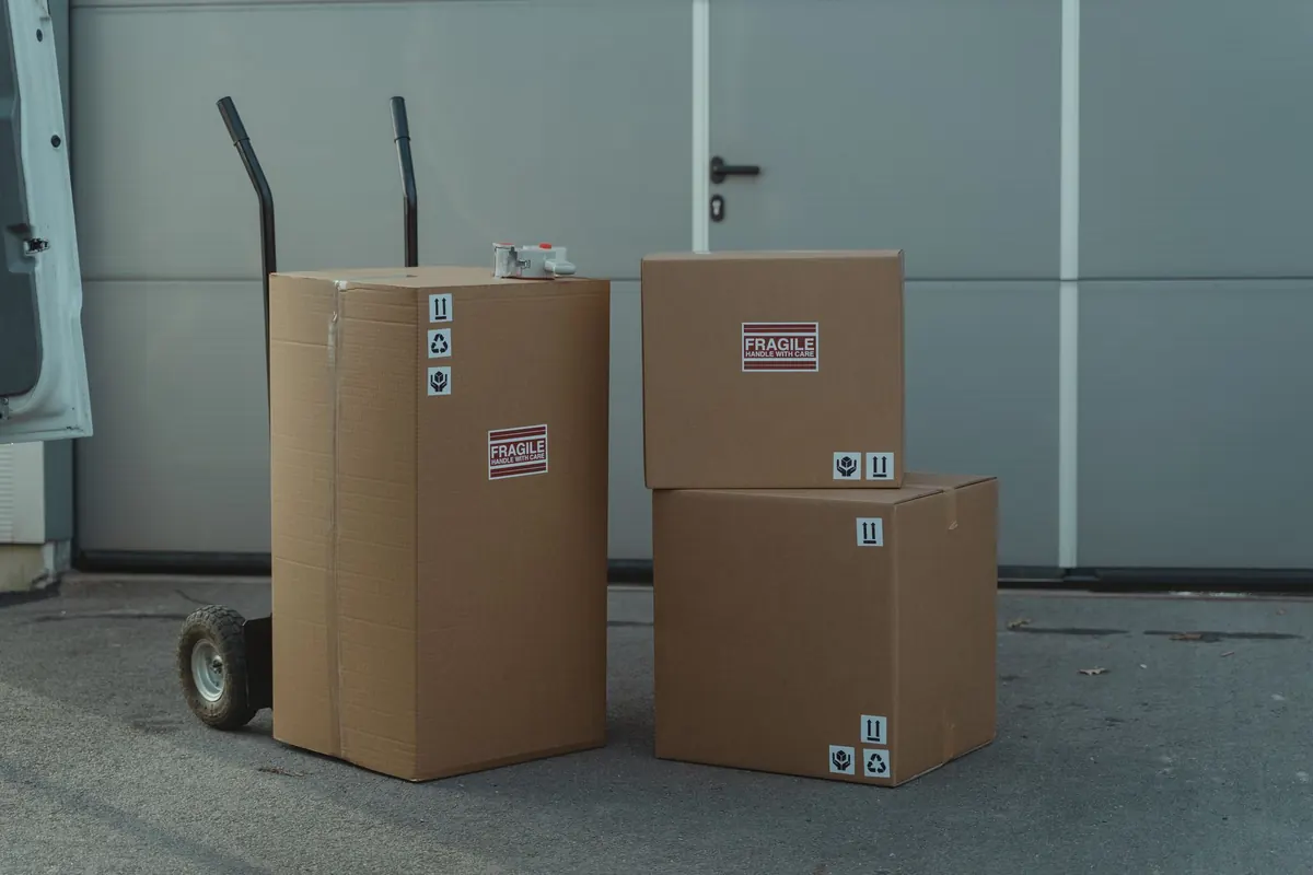 Kartons stehen auf einem Rollwagen vor einer freien Laderampe