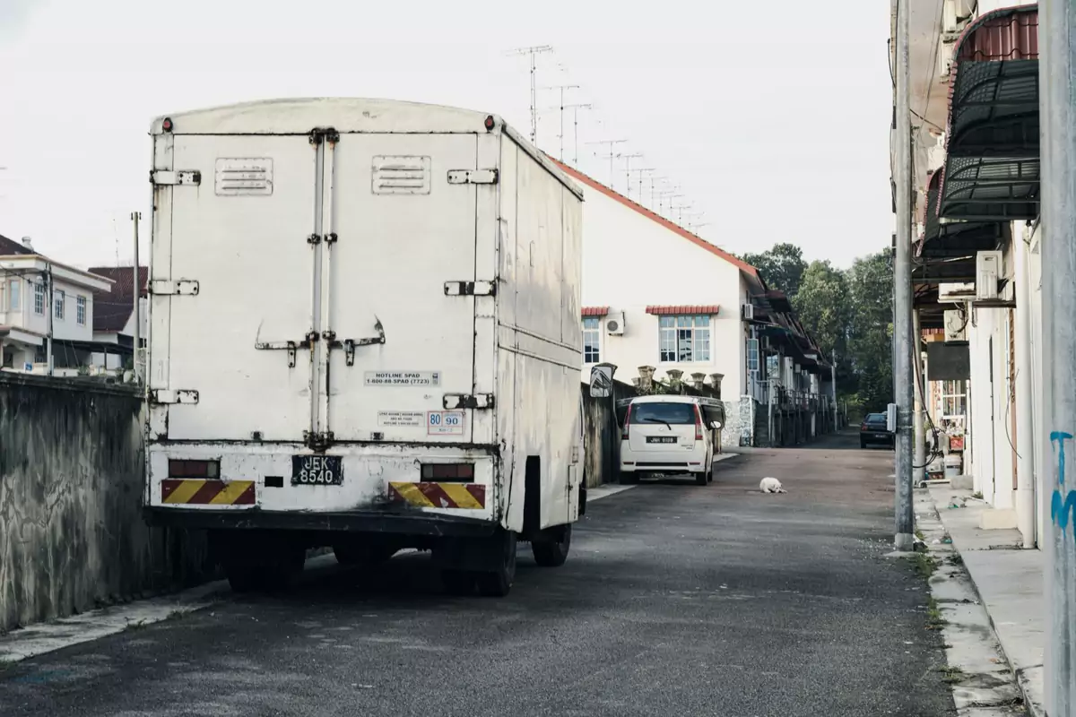 Ein neutraler Koffer-LKW steht für den Möbeltransport in einer Wohnstraße bereit