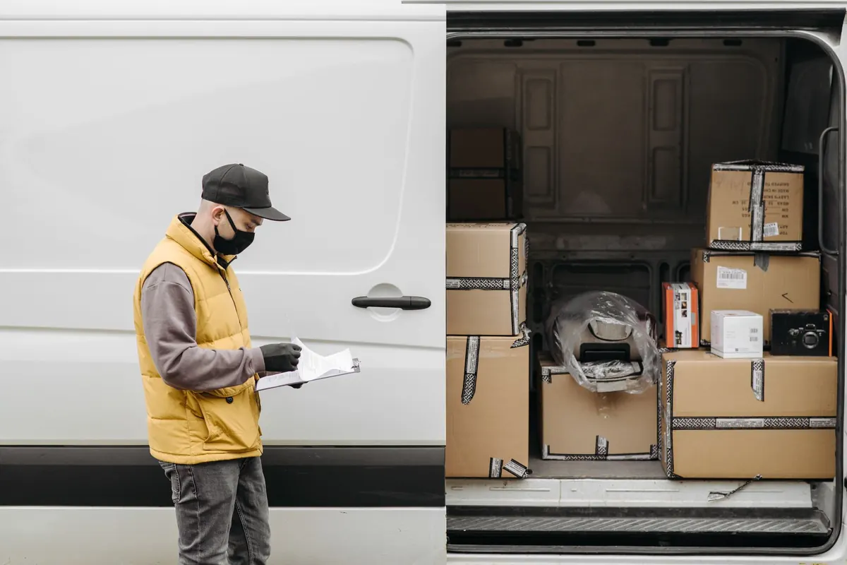 Ein Helfer prüft Kartons im offenen Laderaum eines Transporters