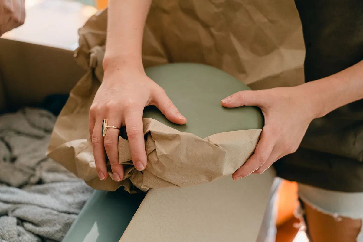 Zerbrechlicher Hausrat wird vor dem Einpacken in Papier eingeschlagen